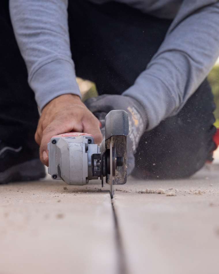 Old cracked mastic being fully removed from a pool expansion joint