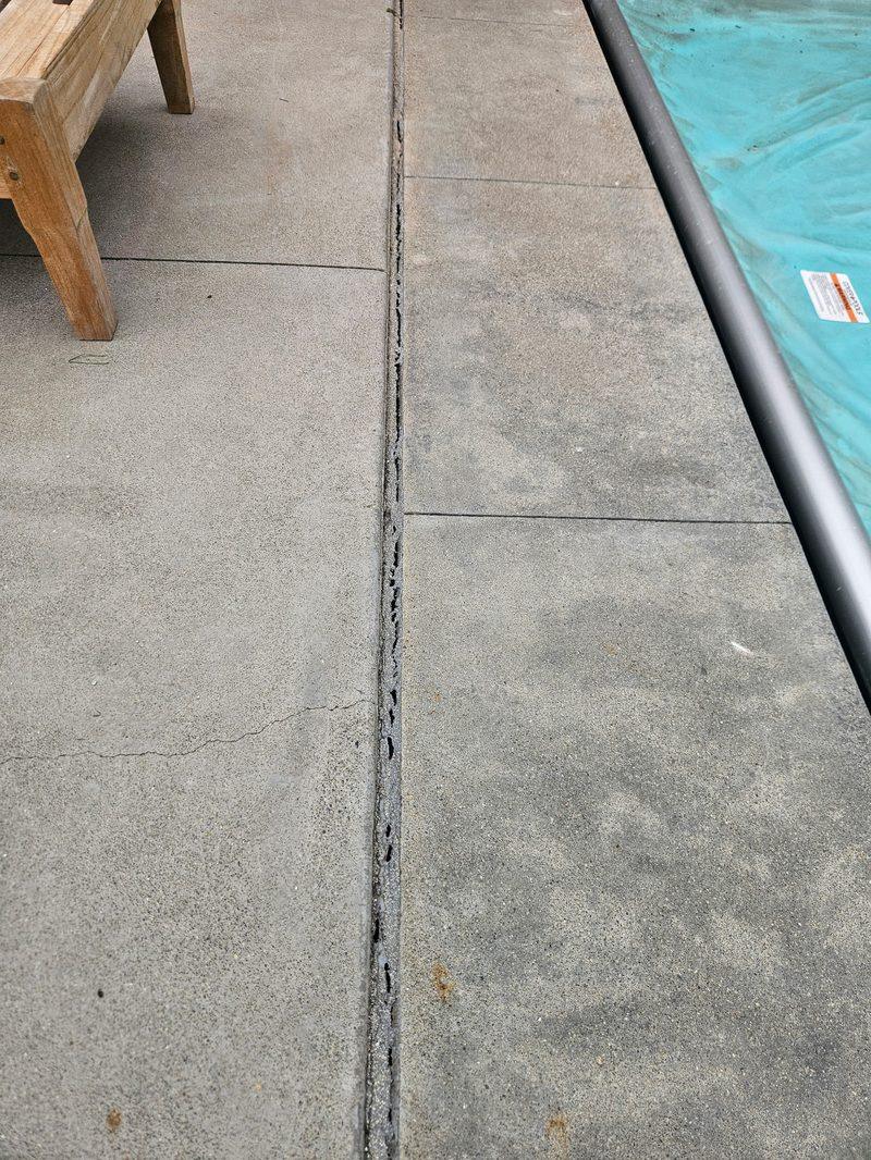 A full run of failed joint filler beside the pool