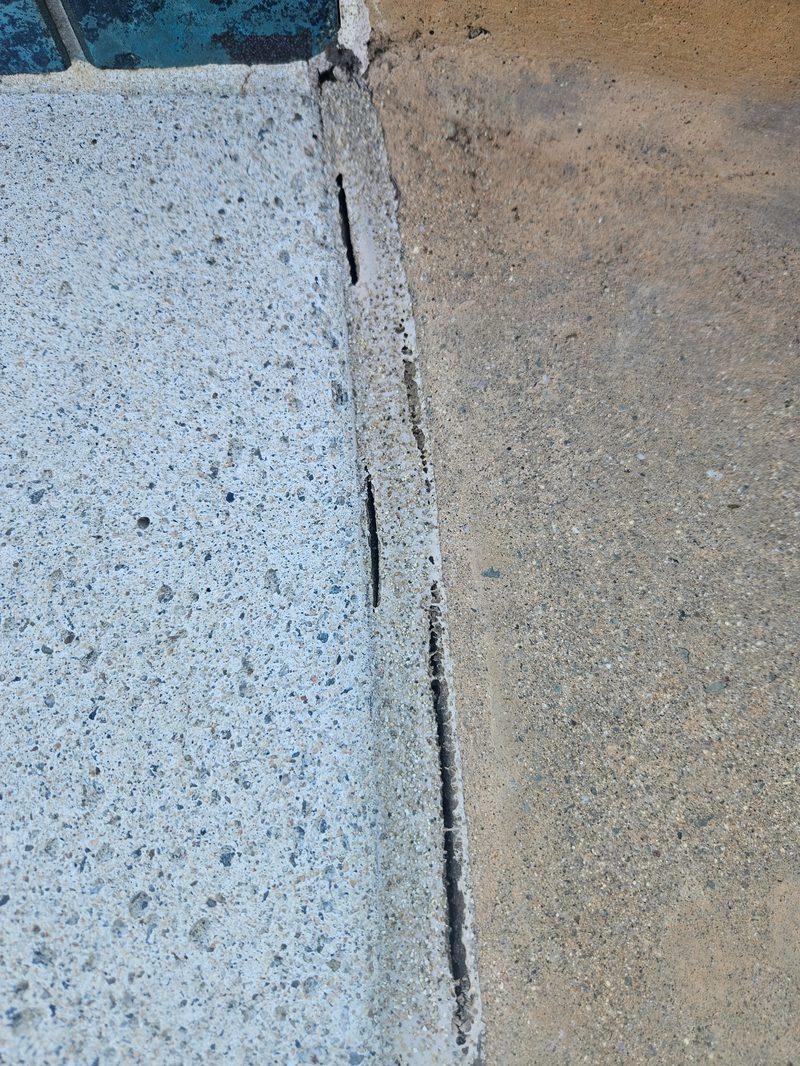 Old sealant split and pulled away beside the waterline tile