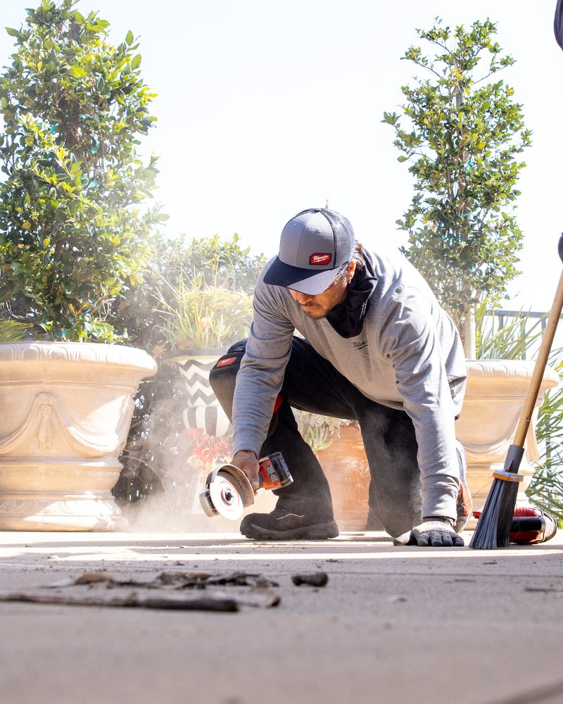 Technician grinding the concrete joint faces clean before new mastic goes in